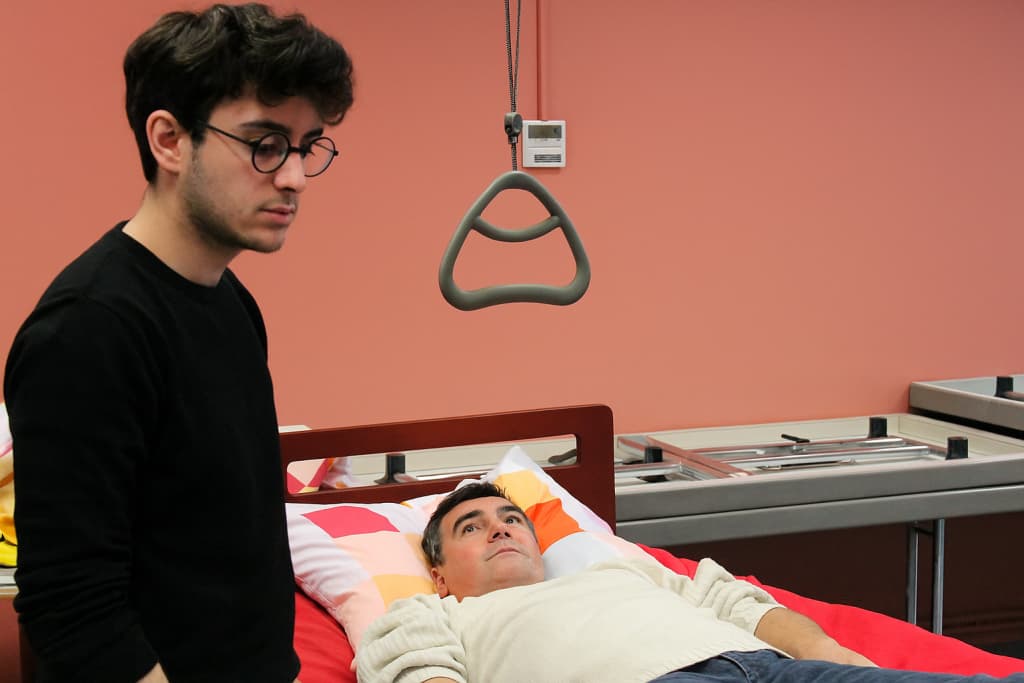 Formation-gestes-postures-soins Jeune homme enseignant des gestes et postures à un patient